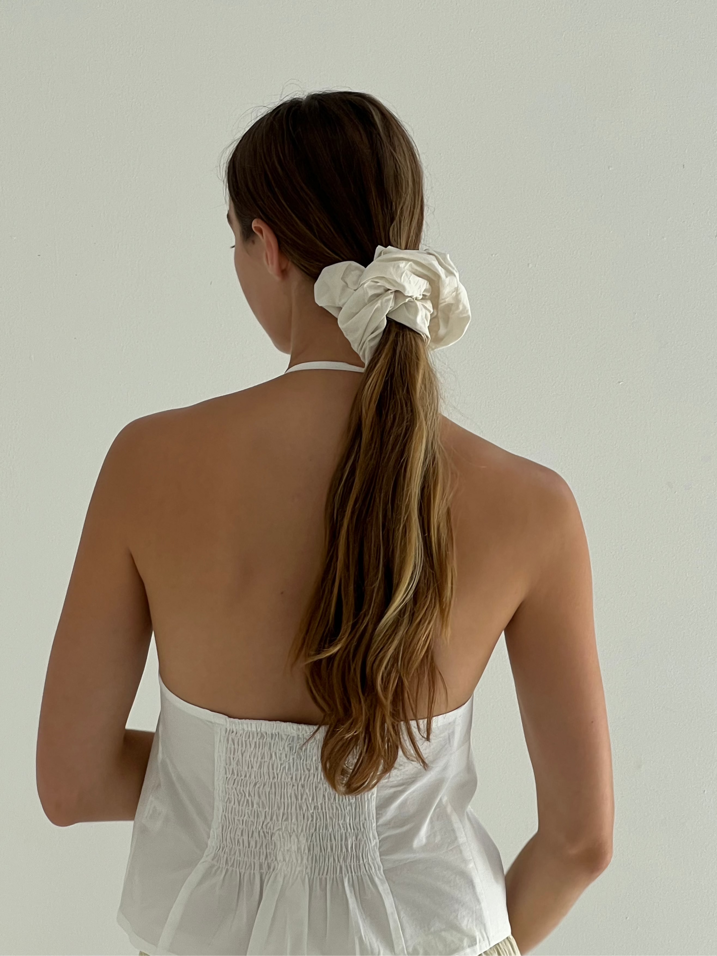 female model wears the open halter top top by Deiji Studios in white

top features open front with centre bust tie, halter neck tie and v neckline, bust seams for subtle shaping and shirred back

made from 100% GOTS certified organic cotton poplin
