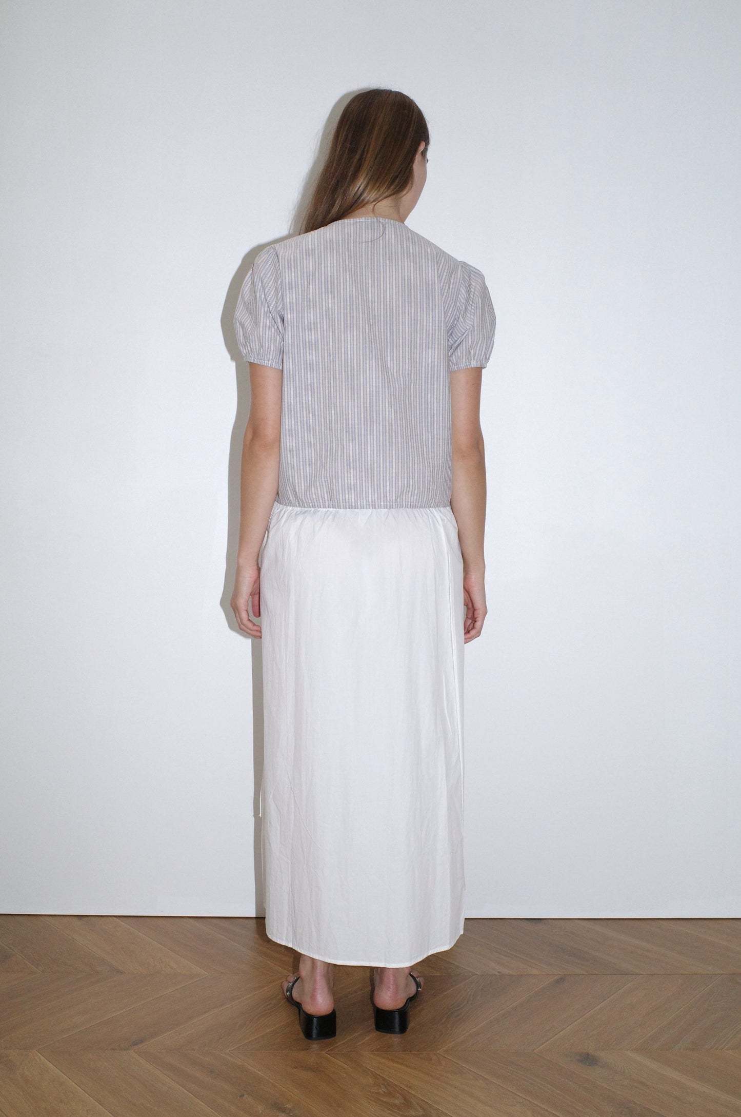 female model wears the double frill top by Deiji Studios in seas stripe



elevated everyday top features a flattering v neckline with button down front, fixed ruffle details, soft blouson sleeve and gathered elastic cuffs


made from 100% GOTS certified organic cotton poplin

paired with a white skirt