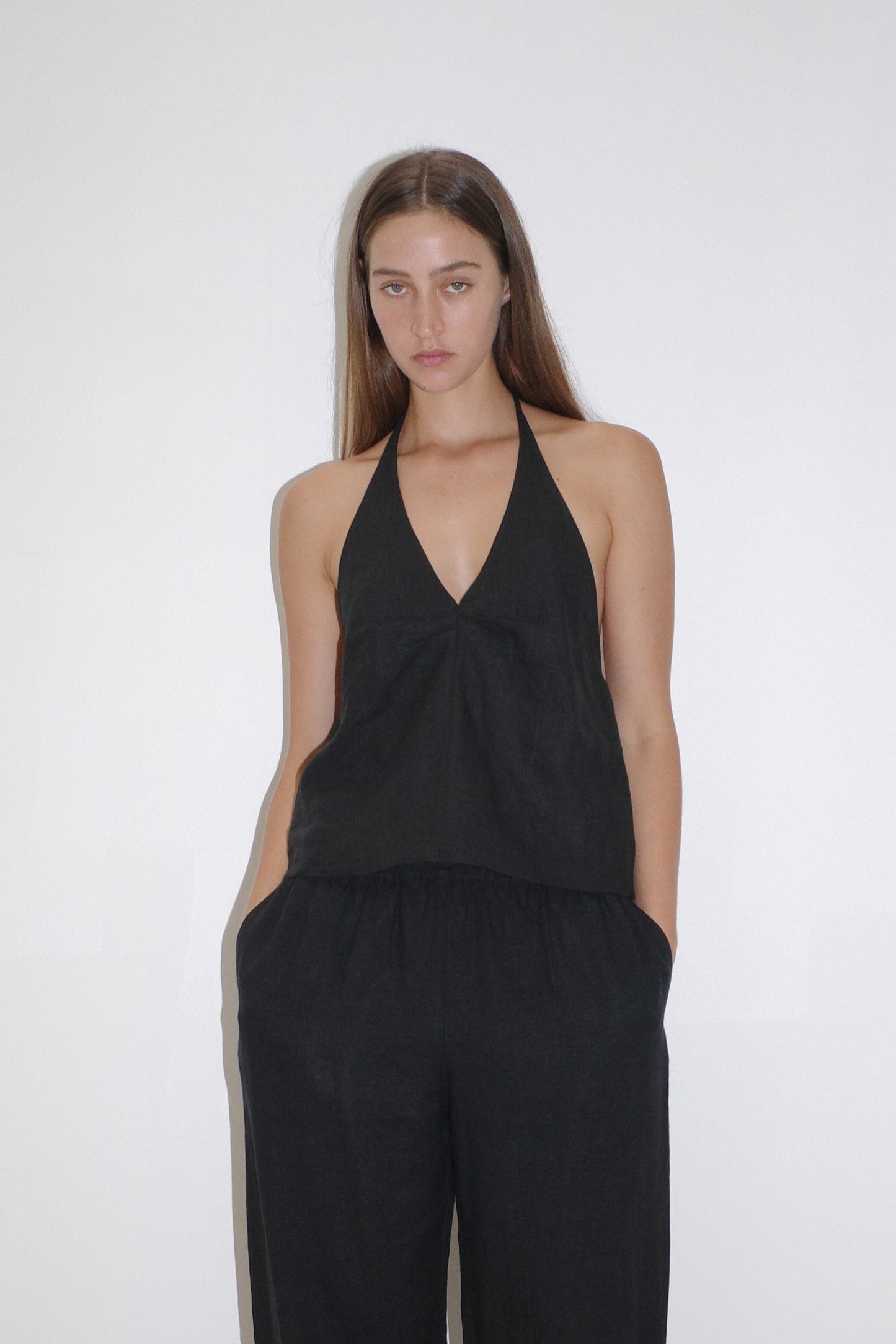 female model wears the linen pinched halter top by Deiji Studios in black

relaxed halter top features flattering v neckline, centre bust pleats and adjustable backline with drawcord tie closure

made from 100% OEKO-TEX 100 certified and EU certified stone washed french linen

paired with a black linen trouser