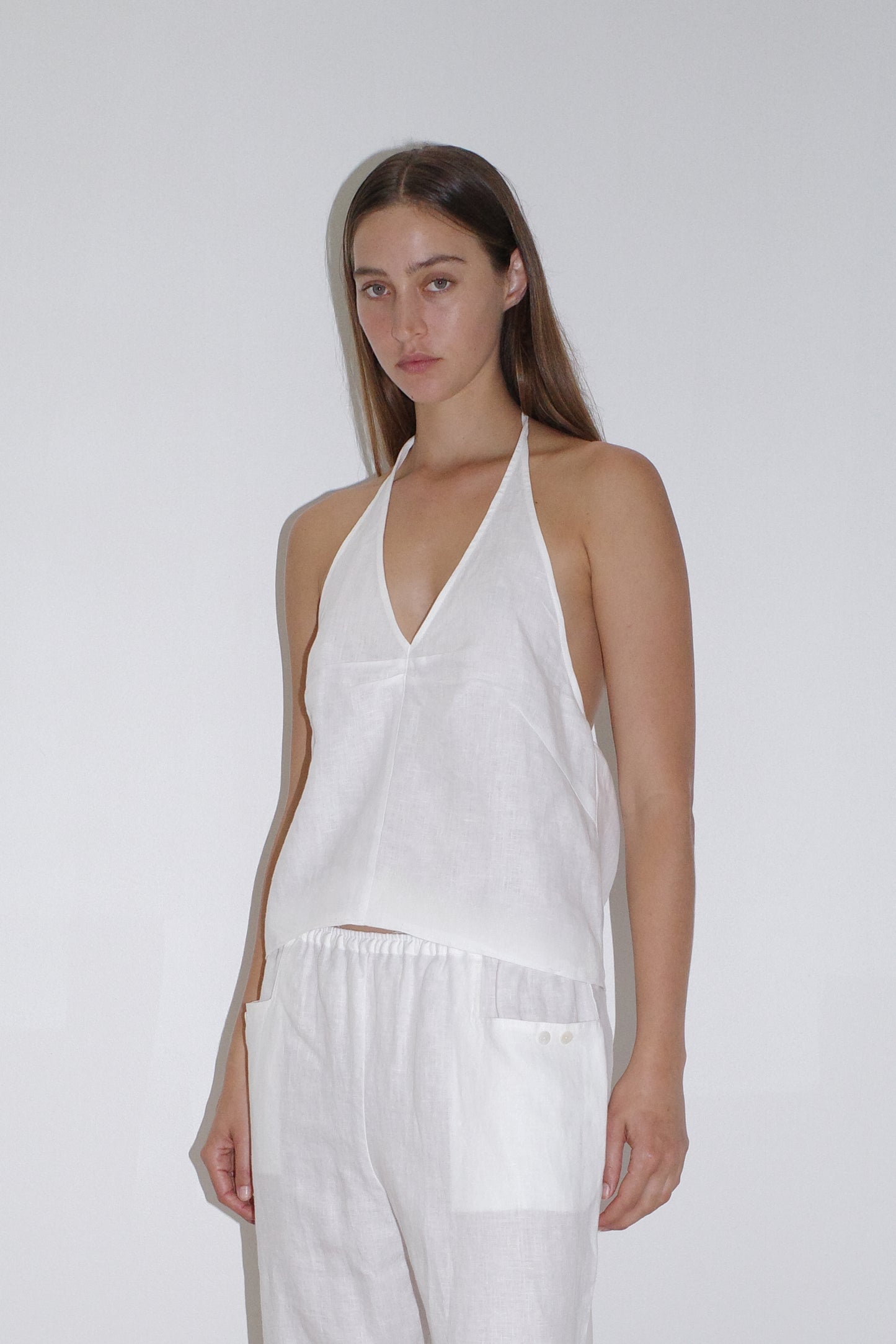 female model wears the linen halter top by Deiji Studios in white

relaxed halter top features flattering v neckline, centre bust pleats and adjustable backline with drawcord tie closure

made from 100% OEKO-TEX 100 certified and EU certified stone washed french linen

paired with a white linen trouser