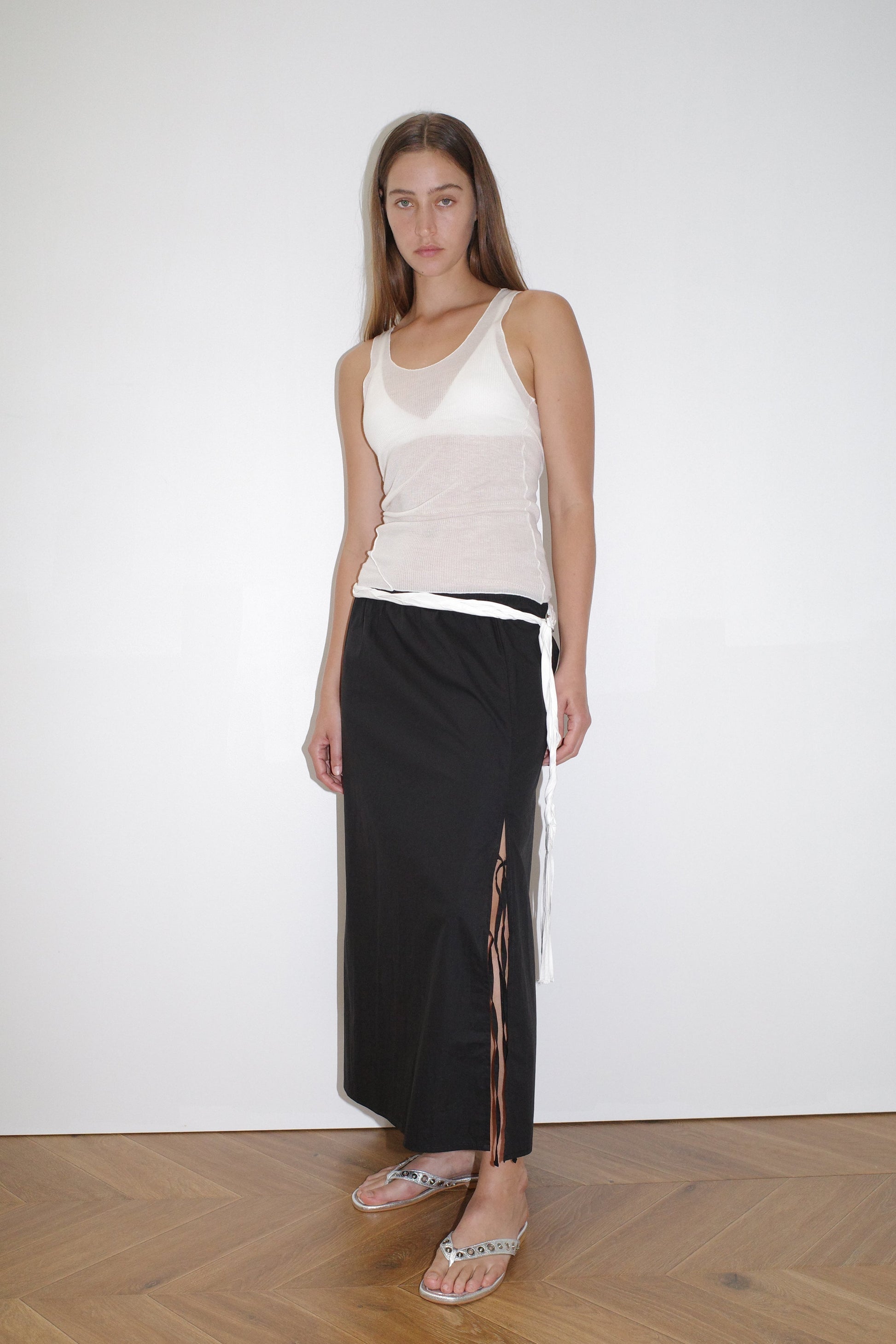 female model wears the split tie skirt by Deiji Studios in black


a mid length, airy skirt designed to sit mid-rise with a soft gathered elastic waist and split side featuring two ties


made from 100% GOTS certified organic cotton poplin

paired with a sheer knit tank in off white