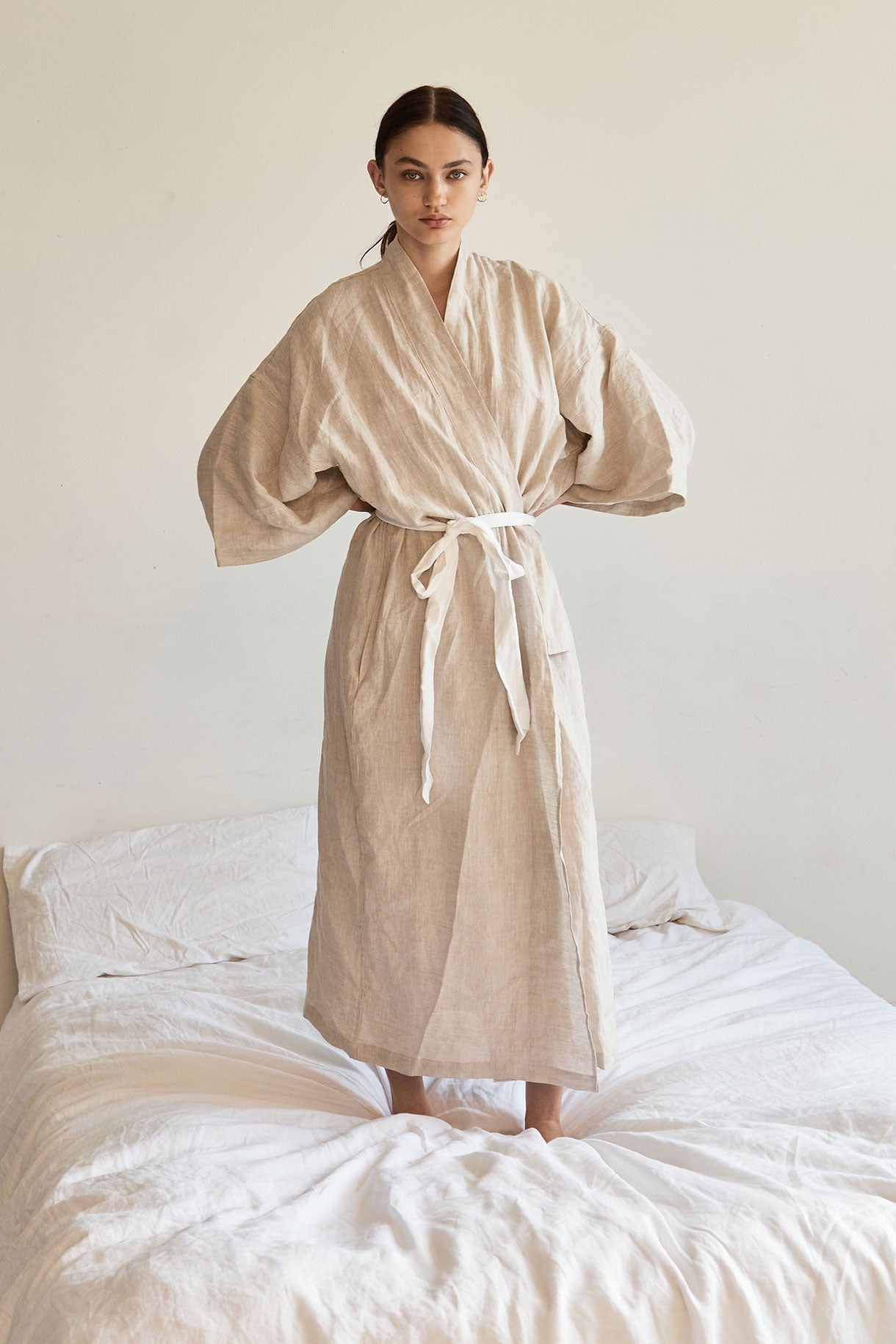Female model wearing the 02 robe - oatmeal by Deiji Studios against plain background