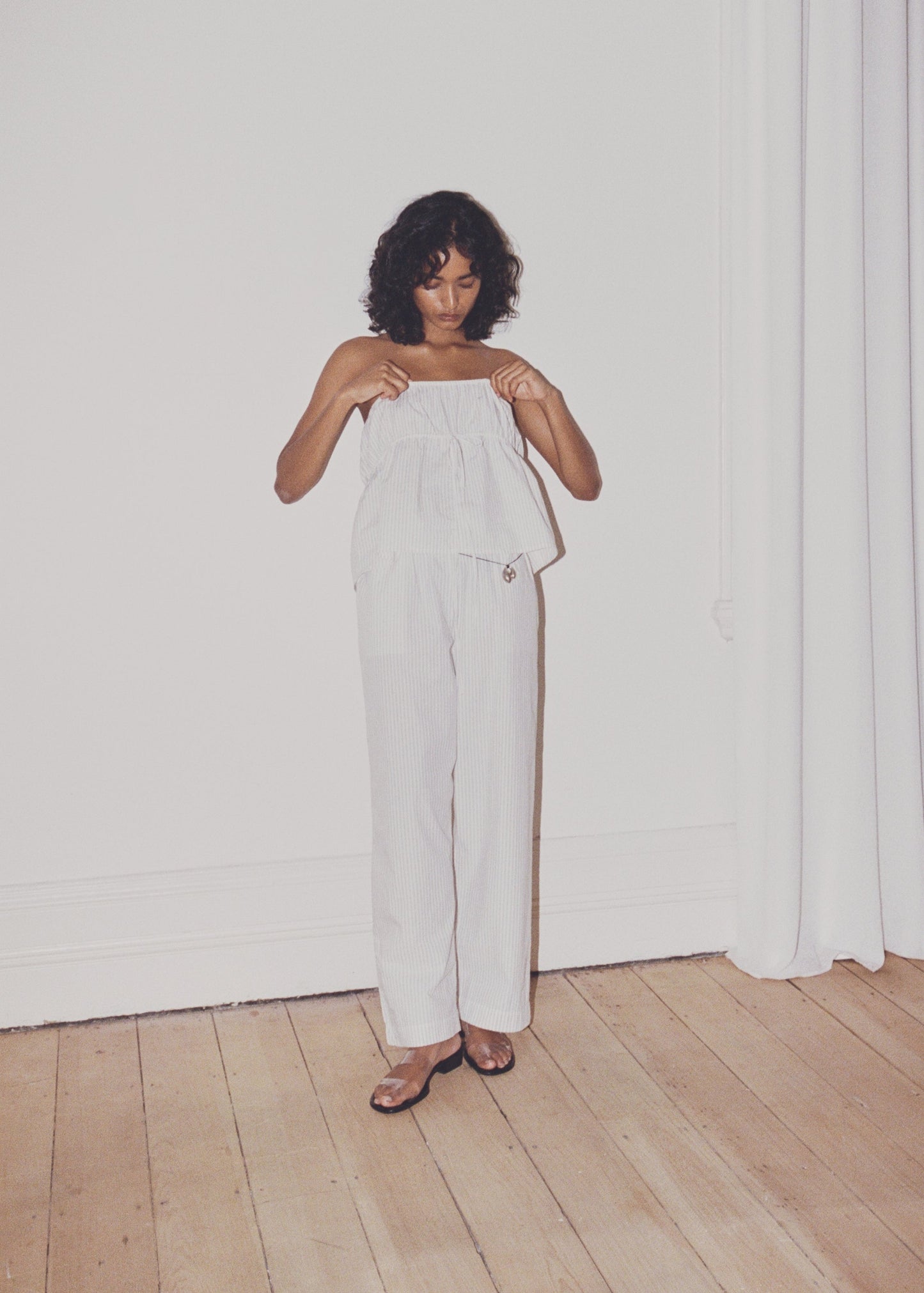 Female model wearing Ease Trouser - Story Stripe by Deiji Studios against plain background